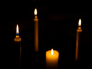 Burning candles with focus on the foreground candle