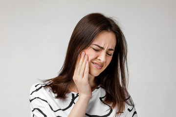 young sad woman suffering from tooth pain, caries. girl having toothache. Dental health and care...