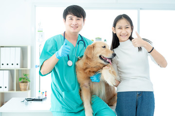 Veterinary concept. Golden Retriever veterinarian and owner showing thumbs up. veterinarian with stethoscope.