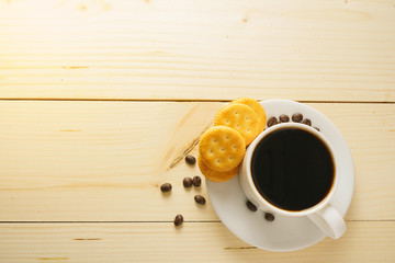 coffee cup with beans and biscuits on wooden desk. flat lay. copy space for your text
