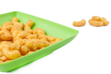 Salty snacks in green plate isolated on white background.Copy space