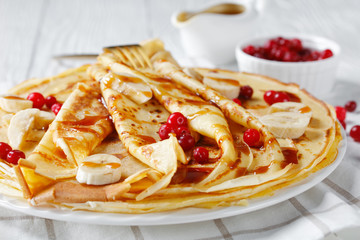 crepes served with berries and caramel sauce