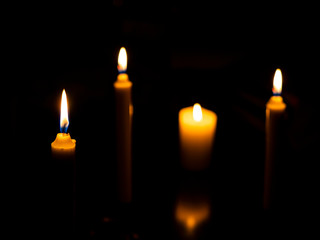 Burning candles with focus on the first and with reflection