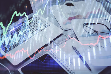 Stock market graph and table with computer background. Double exposure. Concept of financial analysis.
