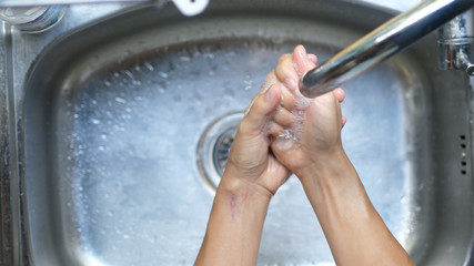 Female hands washing in basin. Top of view