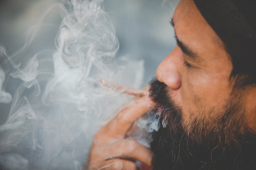 closed up mustache man smoke marijuanna joint