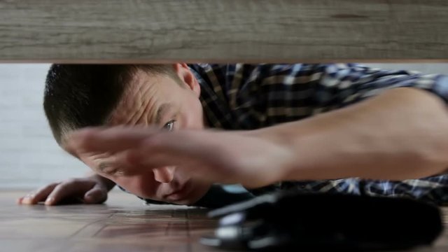 A Young Man Finds A Lost Wallet Under The Bed In The Living Room