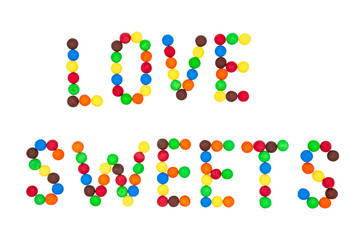 The inscription "love sweets" is laid out with colored candies