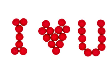 Letters and a heart made of red candies on a white background are laid out