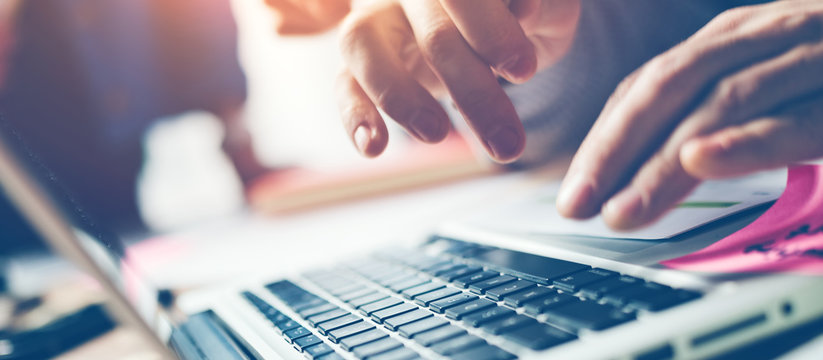 Typing on laptop close-up. Meeting report in progress. Film effect. Wide screen. Panoramic