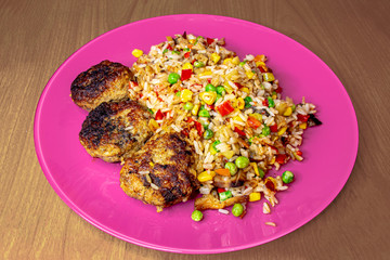 Cutlets with vegetable mixture on a pink plate