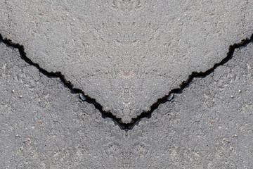 Cracks in the old gray asphalt. Abstract background