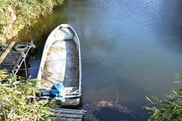 Image of Boat floating on a forgotten moat - obrazy, fototapety, plakaty