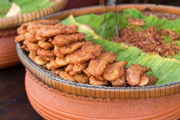 fried banana fritters on green leaf background