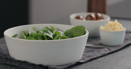d fresh spinach leaves in white bowl