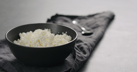 cottage cheese into black bowl closeup