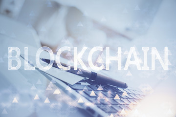 Multi exposure of blockchain and crypto economy theme hologram and table with computer background....