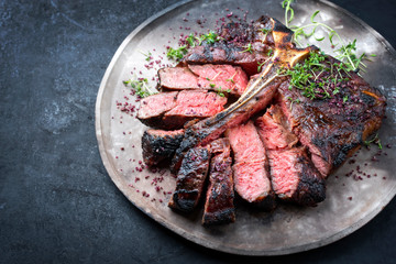 Barbecue dry aged wagyu porterhouse beef steak sliced with large fillet piece with herbs and red...