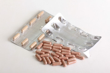 Pills and thermometer on a medical table