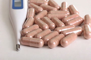 Pills and thermometer on a medical table