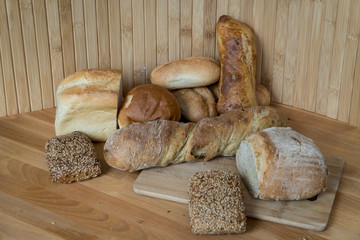 Bread Loafs, Buns And Baguettes On Wooden Choppin Board