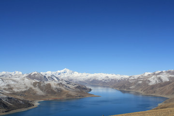 yamdrok lake the fresh water lake in Tibet in fan-shaped or scopion shape surround with snow mountain and clear blue sky