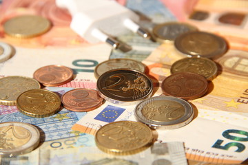 a plug with eurobanknotes and small money