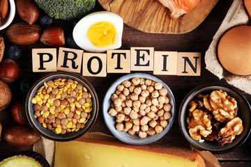 healthy eating and diet concept, natural rich in protein food on rustic table with wooden letter protein