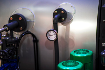 pressure gauge psi meter in pipe and valves of water system industrial focus left closeup white...