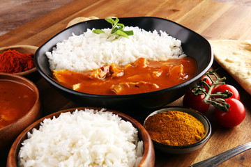 Chicken tikka masala spicy curry meat food in pot with rice and naan bread. indian food on table