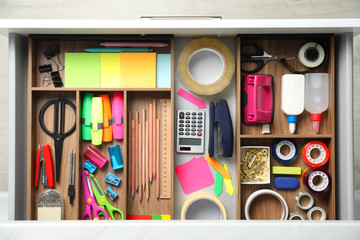 Different stationery in open desk drawer, top view