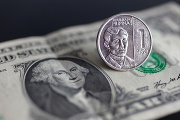Cash banknote of one US dollar and one peso Philippine coin. Money exchange, currency