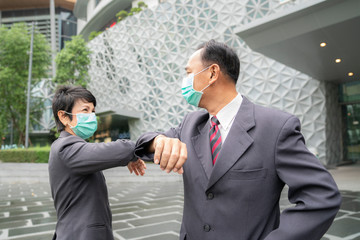 Old asian business people greeting togather by new methode with mask for prevent covid 19