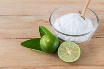 Baking soda with lemon on wooden background