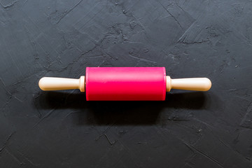 close up of wooden rolling pin on black table