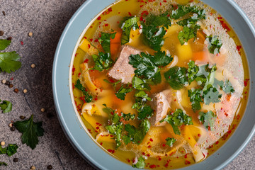 Delicious spicy soup with beef and noodle on grey background. Top view. Macro