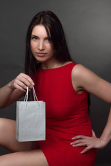Fototapeta na wymiar portrait of a brunette on gray studio background in a red dress