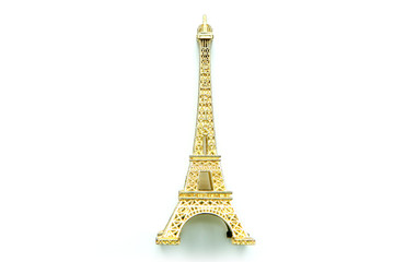 The small golden Eiffel tower as a souvenir from Paris. Isolated on a white background. 