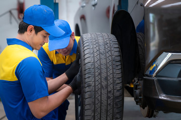 Asian Professional car mechanic changing car wheel in auto repair service