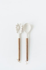Salad serving utensils set. Wooden spoon and fork on white background. Minimal kitchenware concept.
