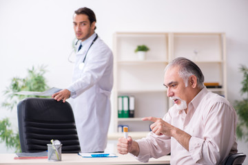 Young male doctor and old patient in antismoking concept