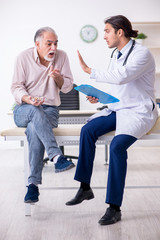 Young male doctor and old patient in antismoking concept