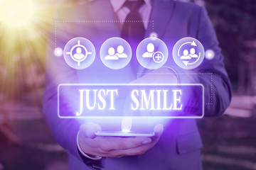 Conceptual hand writing showing Just Smile. Concept meaning assume a facial expression indicating...