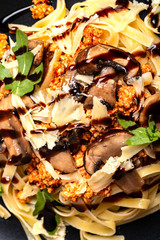 Bolognese pasta with mushrooms and arugula. Macro.