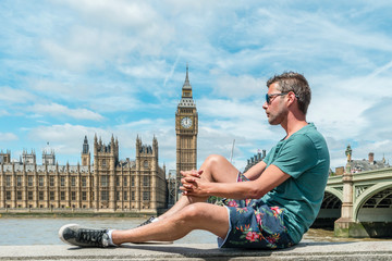 guy on city trip in London, youn men at waterfront by the river Thames at the famous places in...