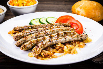 Grilled sausages and vegetables on wooden table