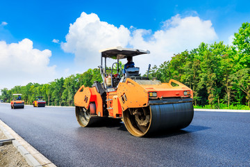 Construction site is laying new asphalt road pavement,road construction workers and road...