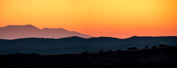 Obraz premium Mountains silhouette sunset skyline red orange colours