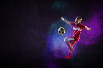 Fototapeta na wymiar Boy playing soccer hitting the ball