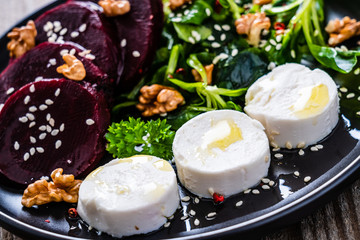  Beetroot salad with goat cheese on wooden background